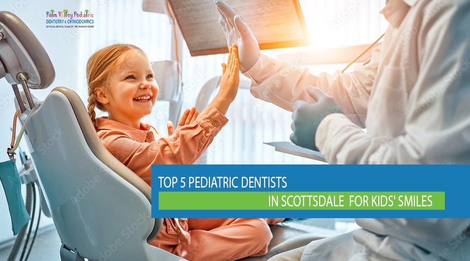Smiling little girl sitting in dentist chair giving high five to friendly pediatric dentist in bright dental clinic